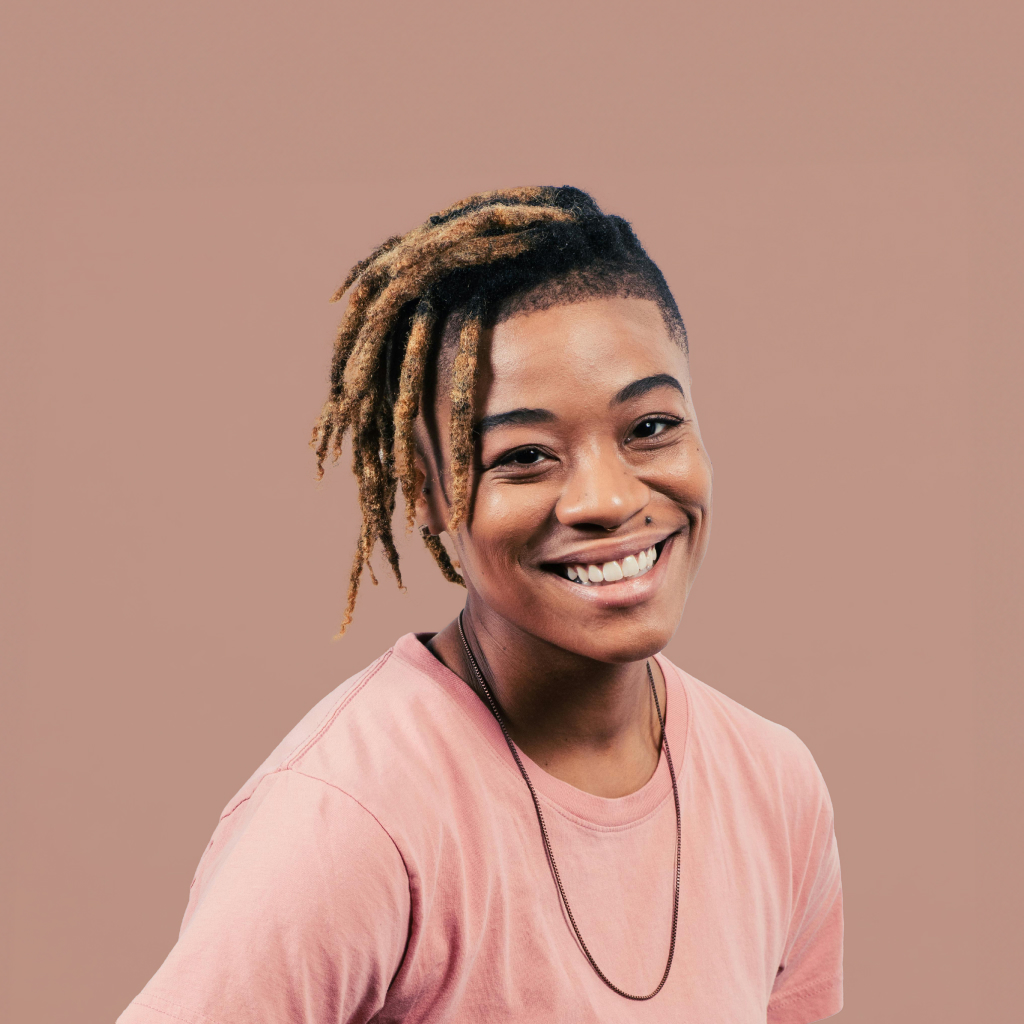 person smiling against a blush background