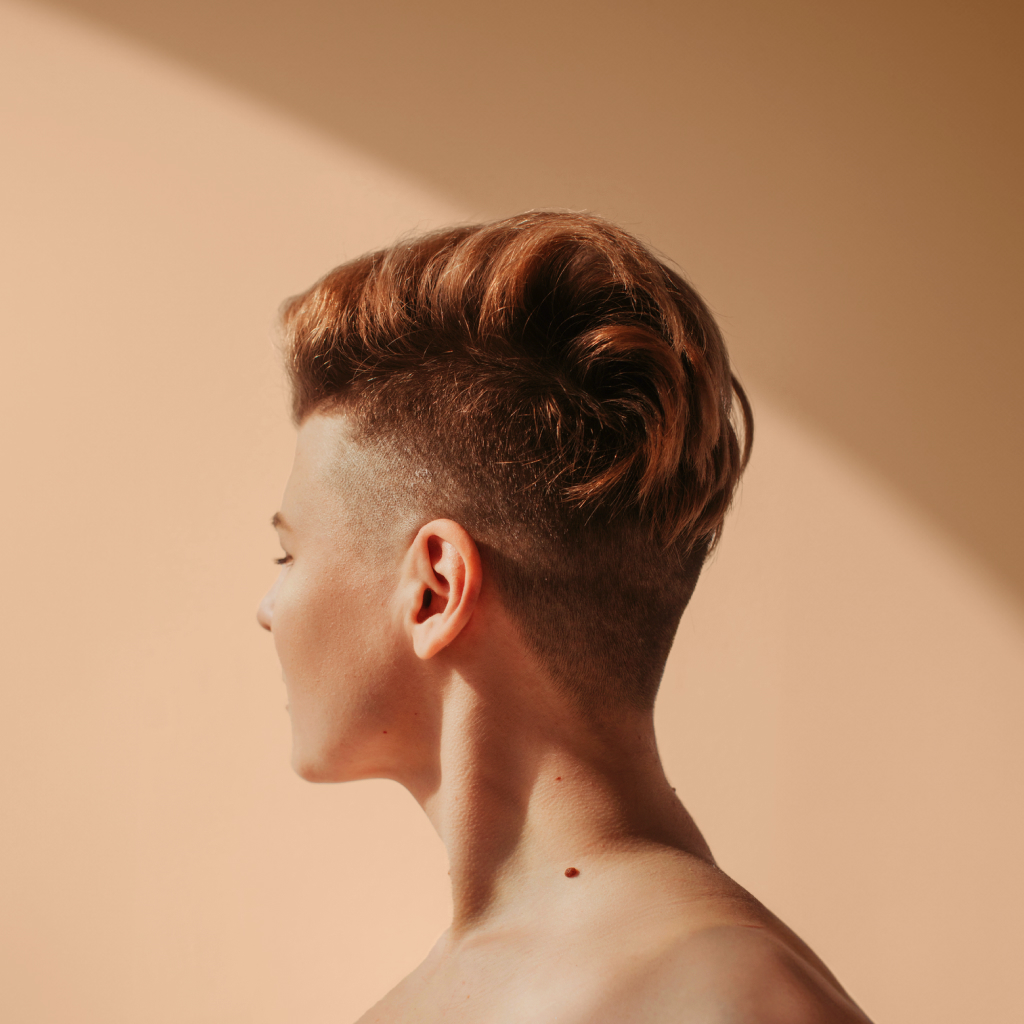 side profile of a person on a peach background