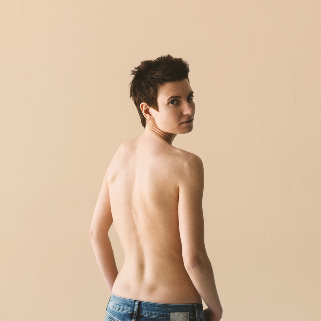 person's facing backward with uncovered torso on a beige background