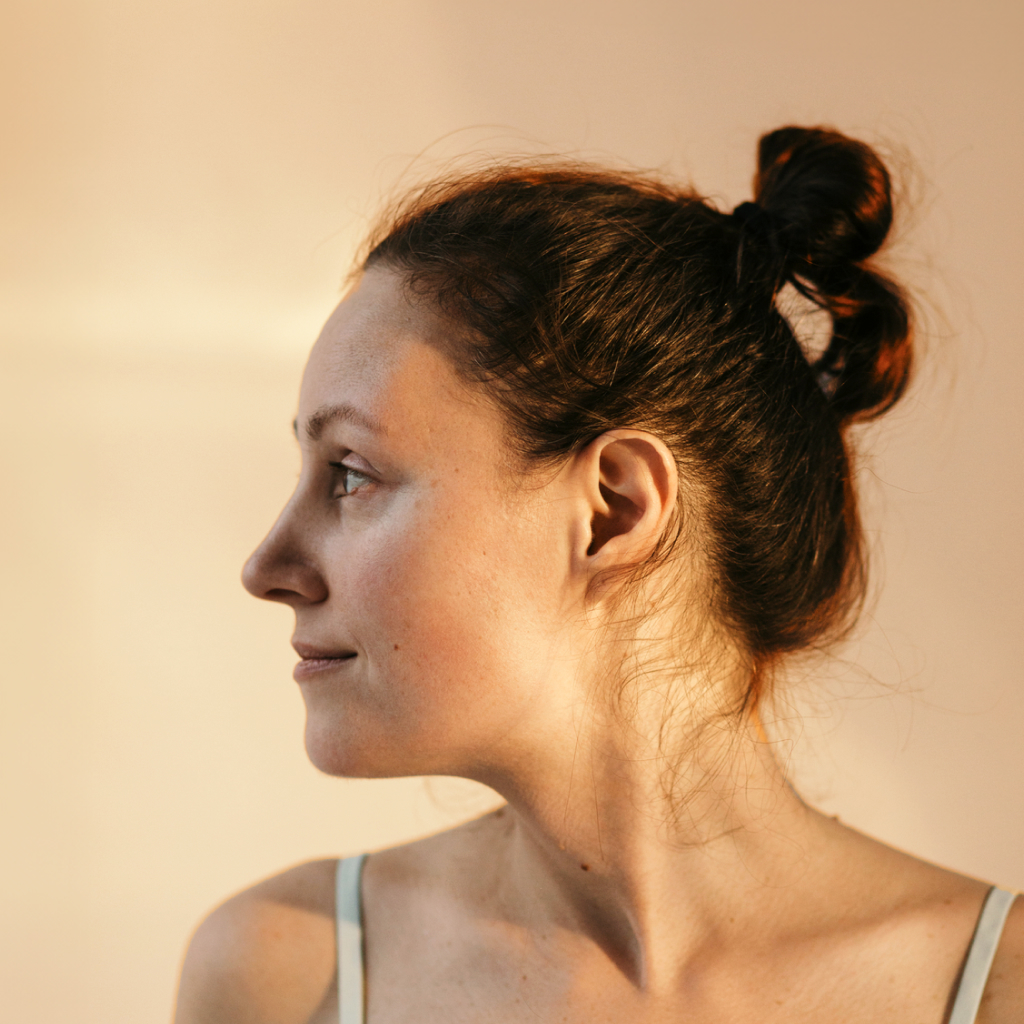 side profile of a women on a cream background