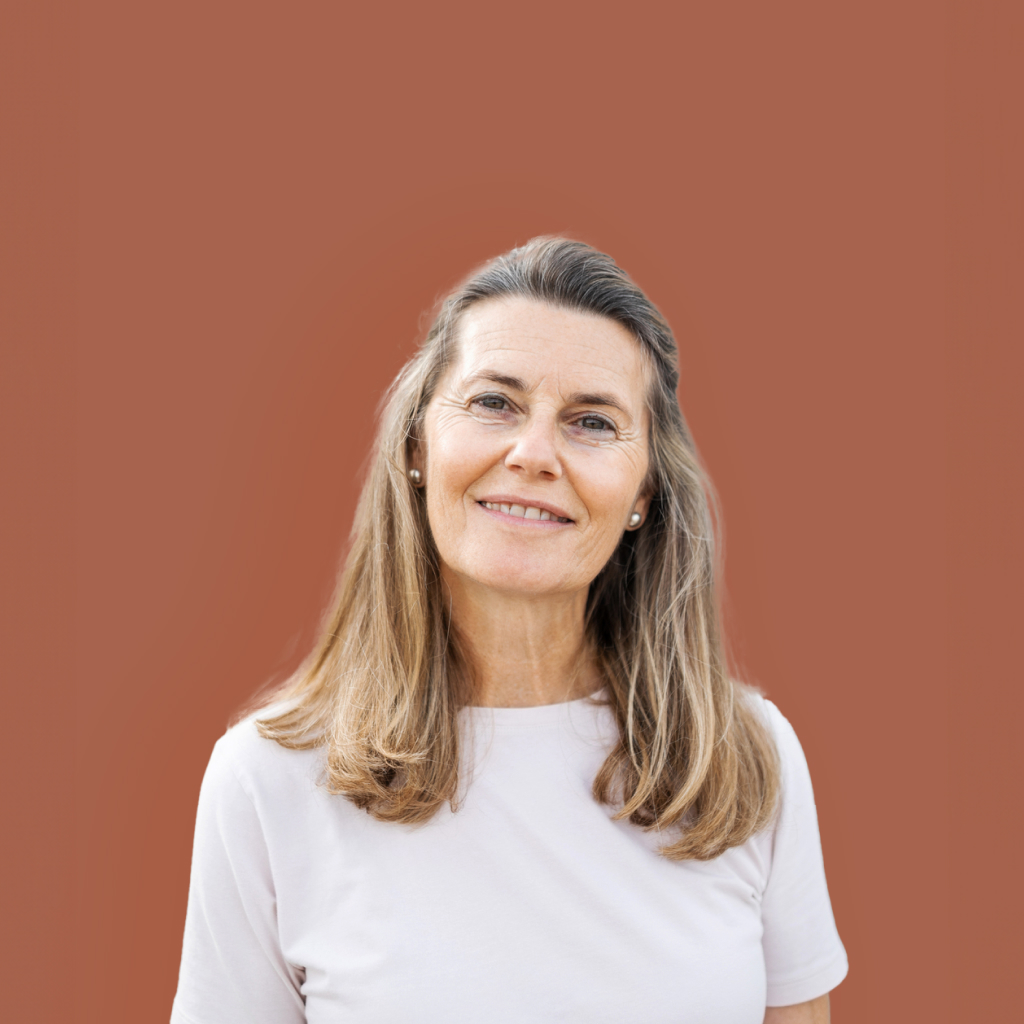 picture of a middle aged women on a rose background smiling