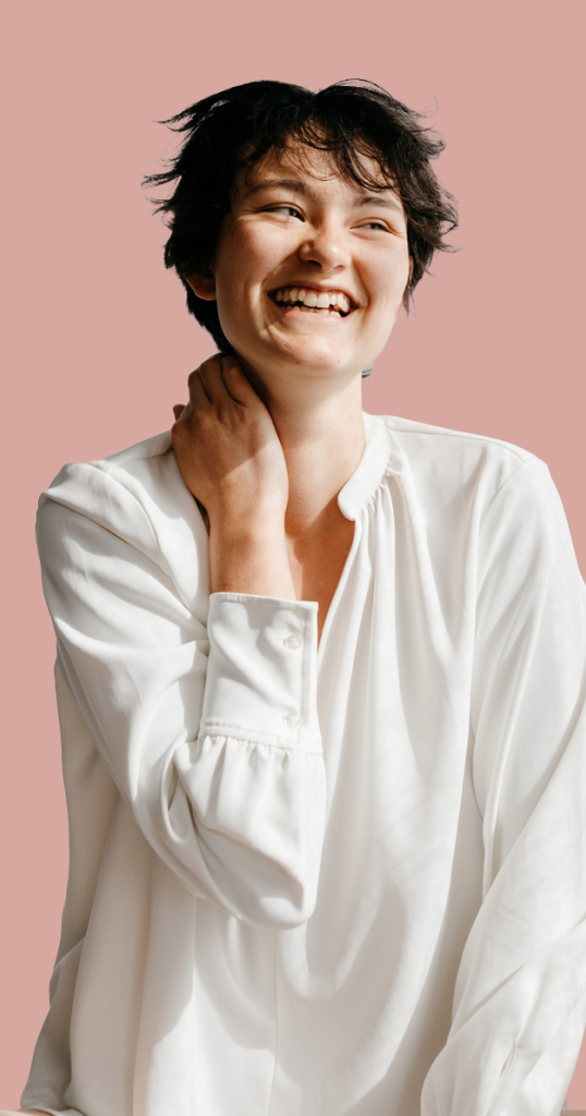 person with long white shirt on blush background